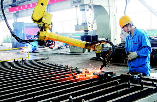 华煤集团矿机厂工人正在利用机械手臂焊接矿机配件 图